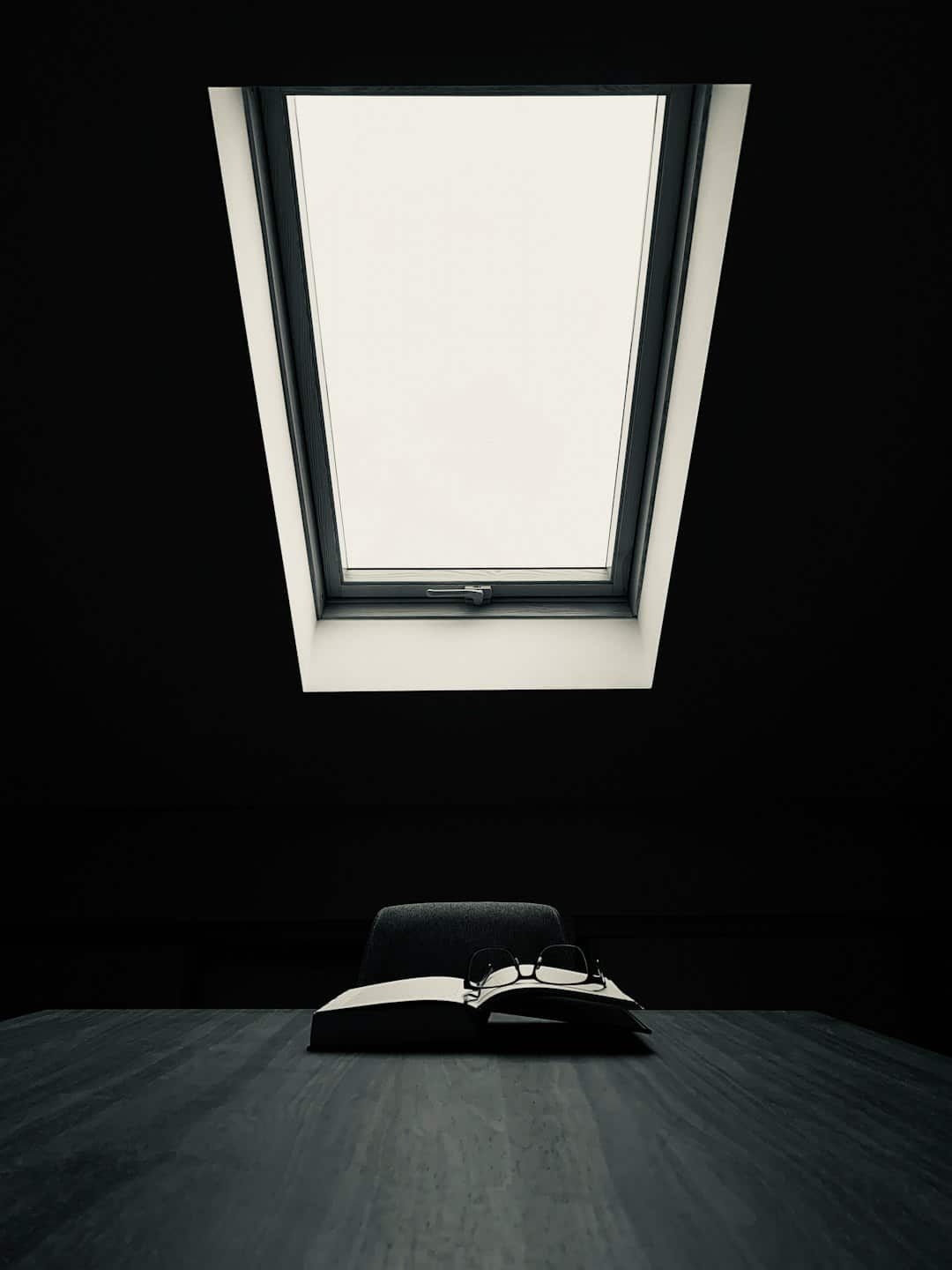Reading glasses on an open book on a desk.